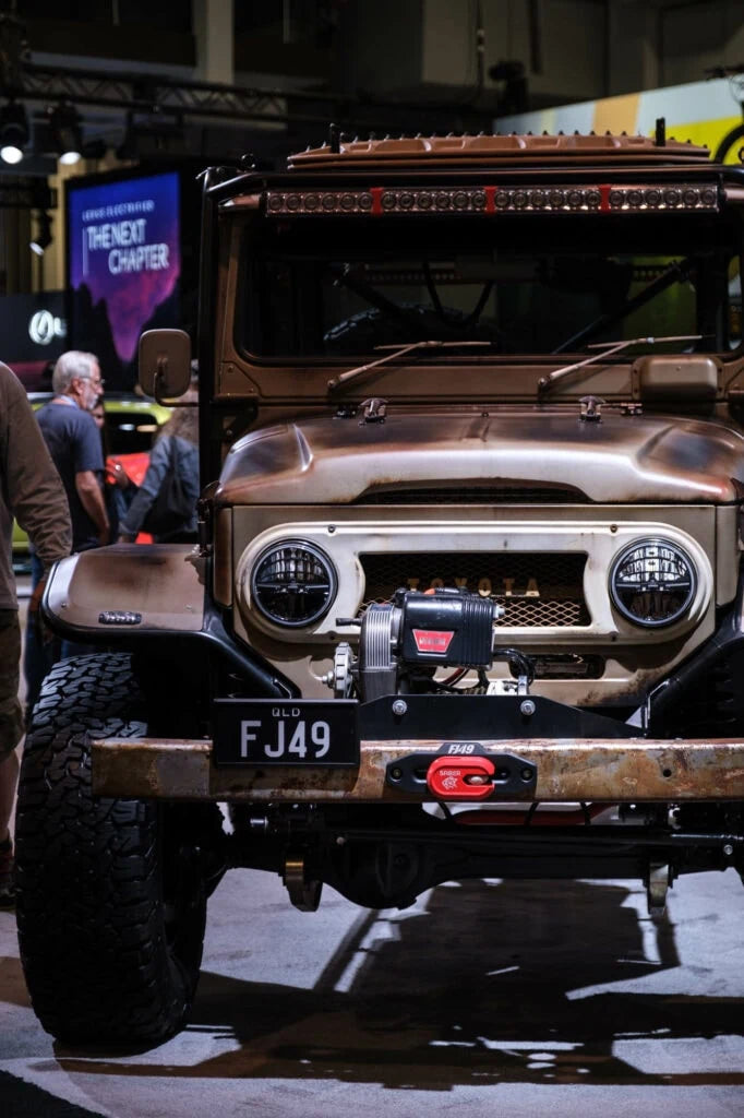 Red Saber Alloy Winch Shackle Short mounted on the FJ49 Toyota Land Cruiser's front bumper at SEMA 2022